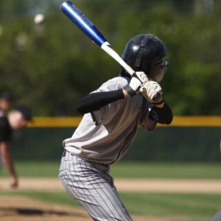 A batter about to hit a pitch during a baseball game.